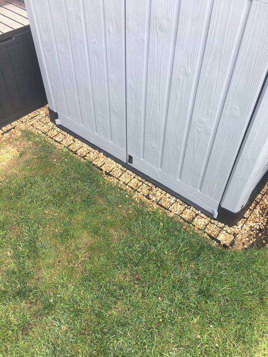 Plastic shed sitting on top of recycled plastic shed base grids